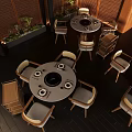 Modern Round Dining Table With Induction Cooker Light Colored Chairs Dark Wooden Floor And Green Plants