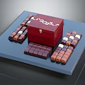 Square Chocolate Pieces Arranged Around Red Wooden Box With White Text On Dark Tray