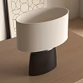 Modern Table Lamp With Cream Lampshade And Black Base On Wooden Table Near Geometric Art