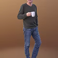 Man Wearing Dark Green Sweater And Blue Jeans Holding White Mug Against Brown Background