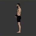 Shirtless Man in Black Shorts with Wrist Wraps Standing on Grey Background