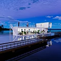 Waterfront Container Building With Staircase Wooden Platform And Small Boat On Lake