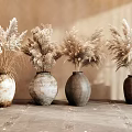 Textured Ceramic Vases With Dried Pampas Grass On Textured Table Against Light Wall
