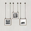 Wooden Frames With Black And White Photos Hanging On Gray Wall With Chains