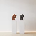 Brown And Black Block Sculptures On White Pedestals With Light Background