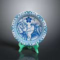 Blue and White Decorative Plate With Floral Border And Two Figure Designs On Green Stand