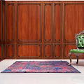 Elegant Green Velvet Single Sofa in Room with Wooden Paneled Walls and Colorful Rug