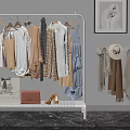 Stylish Clothes on White Rack with Dresses Coats Scarves Hats Bags Shoes and Wall Art