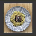 Delicious Roasted Meat With Yellow Rice On Blue White Striped Plate And Wooden Cutting Board