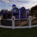 Detached Villa With Blue Dome Arched Windows White Fence Green Lawn And Sunlight