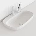 White Oval Bathroom Basin With Modern Faucet On Wooden Countertop And Accessories