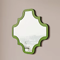 Green Framed Decorative Mirror Hanging On Beige Wall Reflects Outdoor View And Table