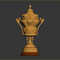Elegant Golden Trophy With Ornate Carvings Lid Handles And Red Base Design
