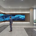 Modern Exhibition Hall Featuring Large Blue Wavy Screen Person Standing Gray Walls and Large Windows