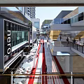 Modern Commercial Street With Pedestrians Red Pavement And Multi level Buildings
