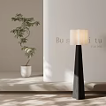 Modern Floor Lamp with Black Stand and White Shade Beside Green Plant on Light Wall