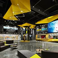 Modern Cinema Interior With Yellow Ceiling Large Screens Seating Area And Bar Counter