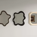 Three Mirrors With Various Shapes And Different Colored Frames Hanging On Wall