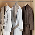 Neatly Arranged Wooden Wardrobe With Hanging Colorful Robes And Folded Towels