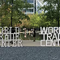 World Trade Center Sculpture in Urban Park with Trees and Visitors Nearby