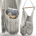 Cozy Light Gray Macramé Hanging Chair With Fringes And Patterned Pillows