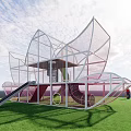 Modern Children's Playground With Metal Slide And Net Structure On Green Grass For Kids Fun