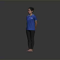 Woman Standing Barefoot In Blue Polo Shirt And Black Pants Against Gray Background