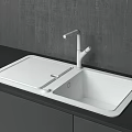 Modern White Kitchen Sink With Wooden Cutting Board And Silver Faucet On Black Countertop