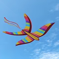 Rainbow Striped Kite With Bird Shaped Wings On Light Blue Background