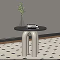 Modern Round Side Table With Black Top White Legs And Green Plant Vase On Books