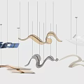 Abstract Wave Shaped Pendant Lights With Metallic Finishes In Blue Gold Brown Tones Hanging