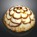 Round Dessert With Creamy White Frosting And Caramel Floral Pattern On Almond Crumb Base