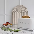 White SMEG Toaster on Marble Countertop with Fruits Wooden Board and Fresh Leaves