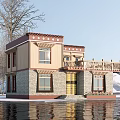 Traditional Tibetan Style Building By Waterfront With Snowy Scenery And Wooden Balcony