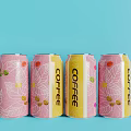 Colorful Coffee Drink Cans With Leaf Patterns And Coffee Beans On Light Blue Background