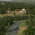 Scenic Rural Forest Landscape With Yurts Cars On Road And Lush Green Grassland