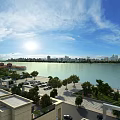 Scenic Lakeside City Landscape With Blue Sky White Clouds Green Trees And Sunshine