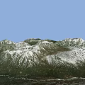 Mountainous Terrain With Snow Covered Peaks And Green Forested Valleys
