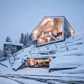 Snowy Hillside Modern Detached Villa Illuminated With Garage And Surrounding Trees