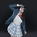 Woman in Blue Blazer White Shirt Red Bow Tie Plaid Skirt Posed on Black Background