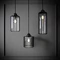 Three Modern Glass Pendant Lights with Cylindrical Shades Hanging Illuminated in Neutral Background