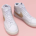 White High Top Shoes Featuring Golden Nike Logo on Pink Background