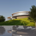 Modern Circular Hotel Building With Glass Facade Green Lawn And Water Reflection