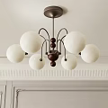 Modern Chandelier with White Spherical Shades and Walnut Center on White Wall with Decorative Molding