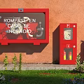 Red Fire Equipment Setup With Fire Box Hose Cabinet Extinguishers And Green Plants On Grass