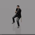 Man Sitting On Chair In Black Blazer Gray Shirt Dark Jeans And Black Sneakers