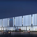 Modern Industrial Factory Building With Large Glass Facade Illuminated At Night And Cars Passing By