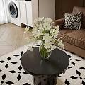 White Flowers in Glass Vase on Black Round Coffee Table with Brown Sofa and Geometric Rug