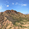 Scenic Mountain Landscape With Rolling Brownish Yellow Peaks Green Grass Blue Sky And White Clouds