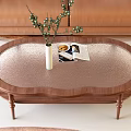 Oval Coffee Table with Textured Metal Top Wood Legs White Vase Green Berries and Magazine